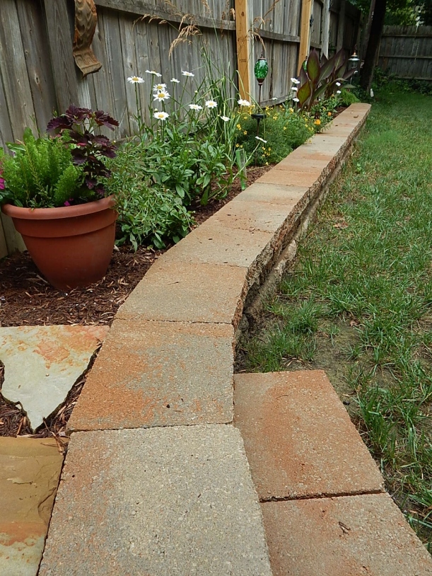 The addition of a step off of the raised area, makes stepping into the yard easier. 